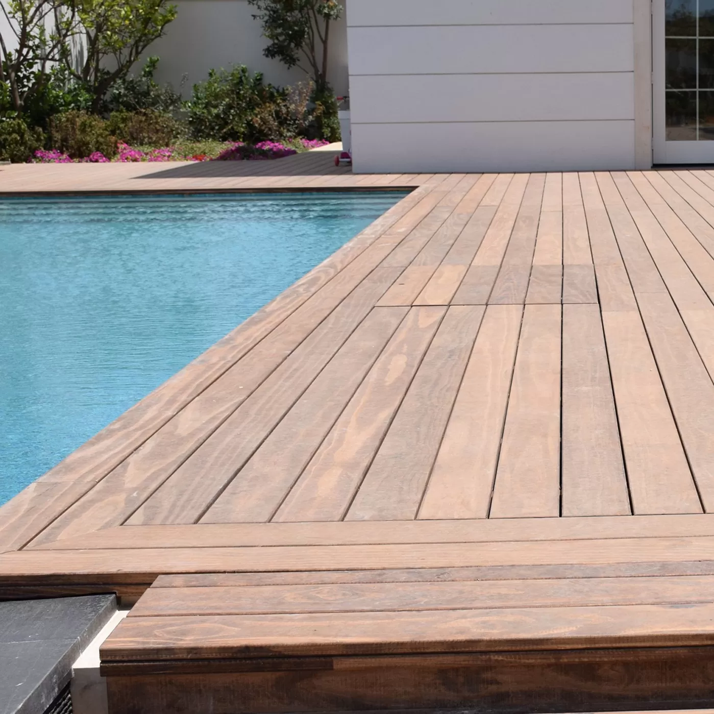 Deck de madera junto a piscina, trabajo de Lignum